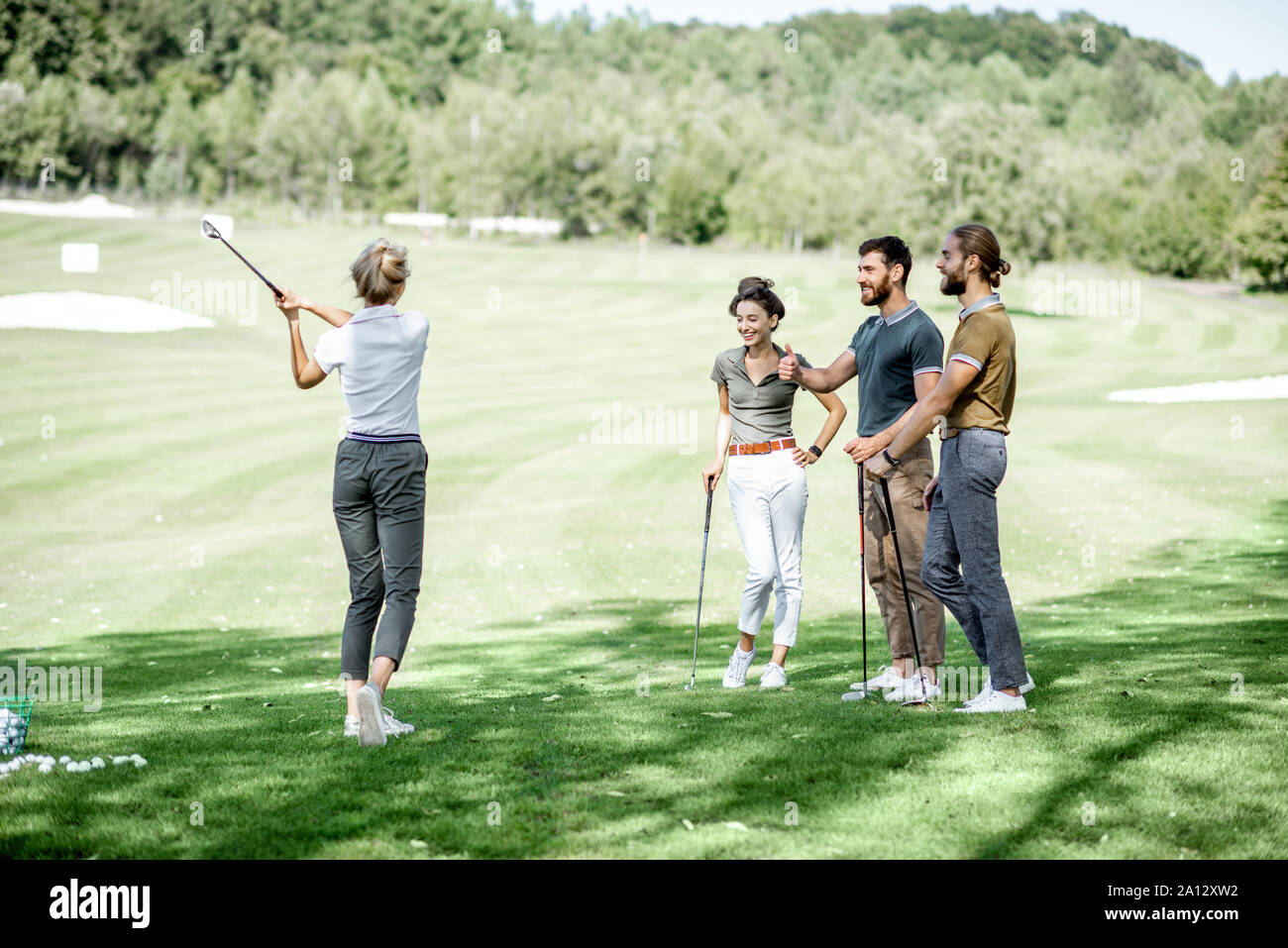 Gruppe von einem jungen Menschen lässig gekleidet, Golf spielen auf dem Golfplatz an einem sonnigen Tag Stockfoto