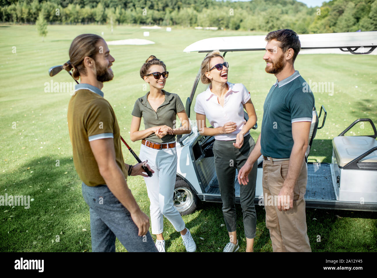 Gruppe von einem jungen gerne Freunde versammeln, bevor das Golfspiel in der Nähe des Auto auf einer spielen, an einem sonnigen Tag Stockfoto