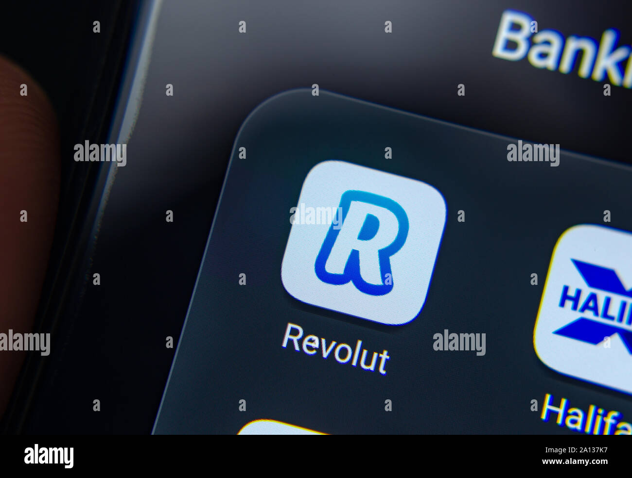 Revolut bank App auf dem Smartphone halten Sie in Händen Haifax bank App ist auch teilweise gesehen. Stockfoto