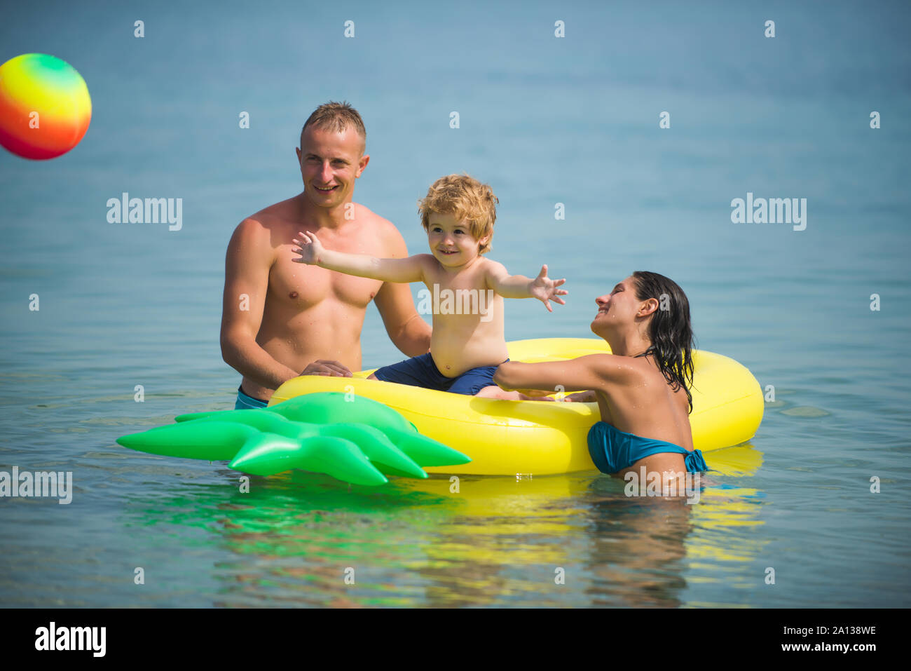 Ananas aufblasbare oder Luftmatratze. Vater und Mutter mit Sohn Ball  spielen im Wasser. Malediven oder Miami Beach Aktivität Freude. Glückliche  Familie Paar auf Cari Stockfotografie - Alamy