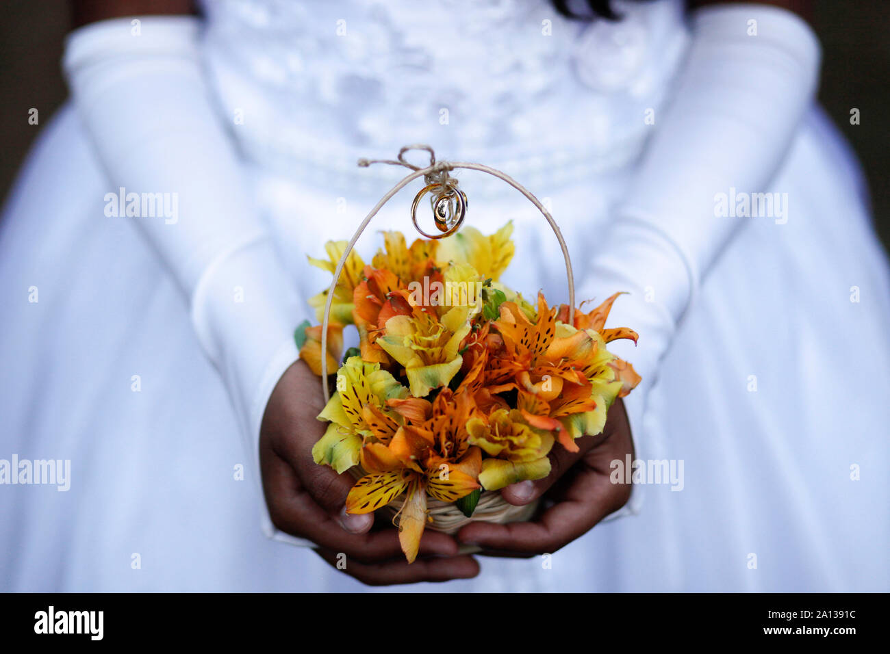 Kind Hände halten Blumenstrauß mit Hochzeit Ringe, Detail der Brautjungfer Hand, die eine Anordnung mit Hochzeit Ringe, Trauringe, Schmuck, trat Han Stockfoto
