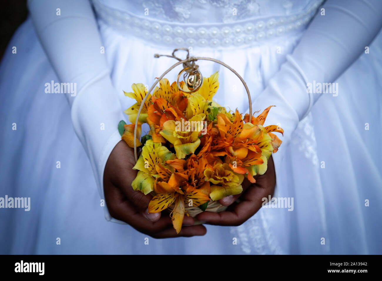 Kind Hände halten Blumenstrauß mit Hochzeit Ringe, Detail der Brautjungfer Hand, die eine Anordnung mit Hochzeit Ringe, Trauringe, Schmuck, trat Han Stockfoto