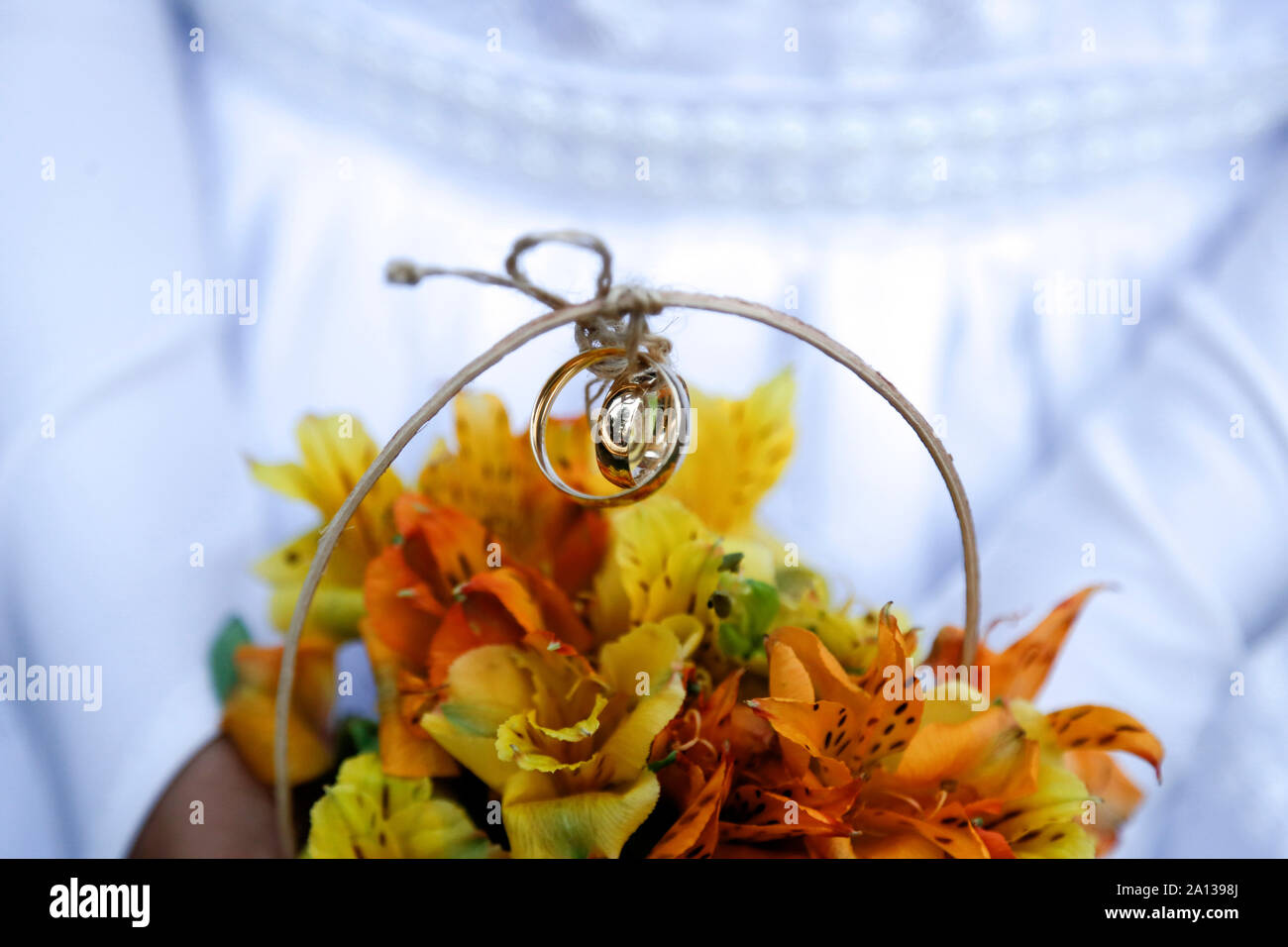 Kind Hände halten Blumenstrauß mit Hochzeit Ringe, Detail der Brautjungfer Hand, die eine Anordnung mit Hochzeit Ringe, Trauringe, Schmuck, trat Han Stockfoto