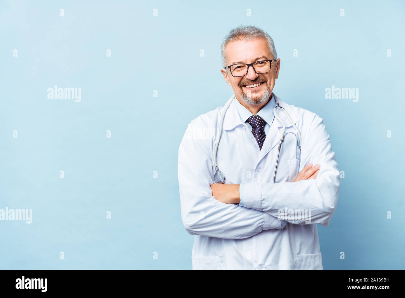Fröhliche reife Arzt posing und lächelnd an Kamera, Gesundheitswesen und Medizin. Stockfoto