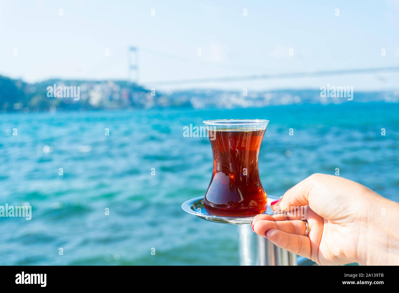 Eine Hand mit einem Tee in Istanbul Bosporus anzeigen Stockfoto