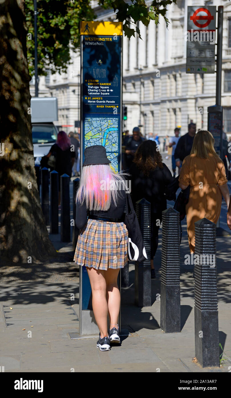 London, England, UK. Junge Frau mit bunten Haare an der Touristeninformation Karte in Whitehall, Westminster suchen Stockfoto
