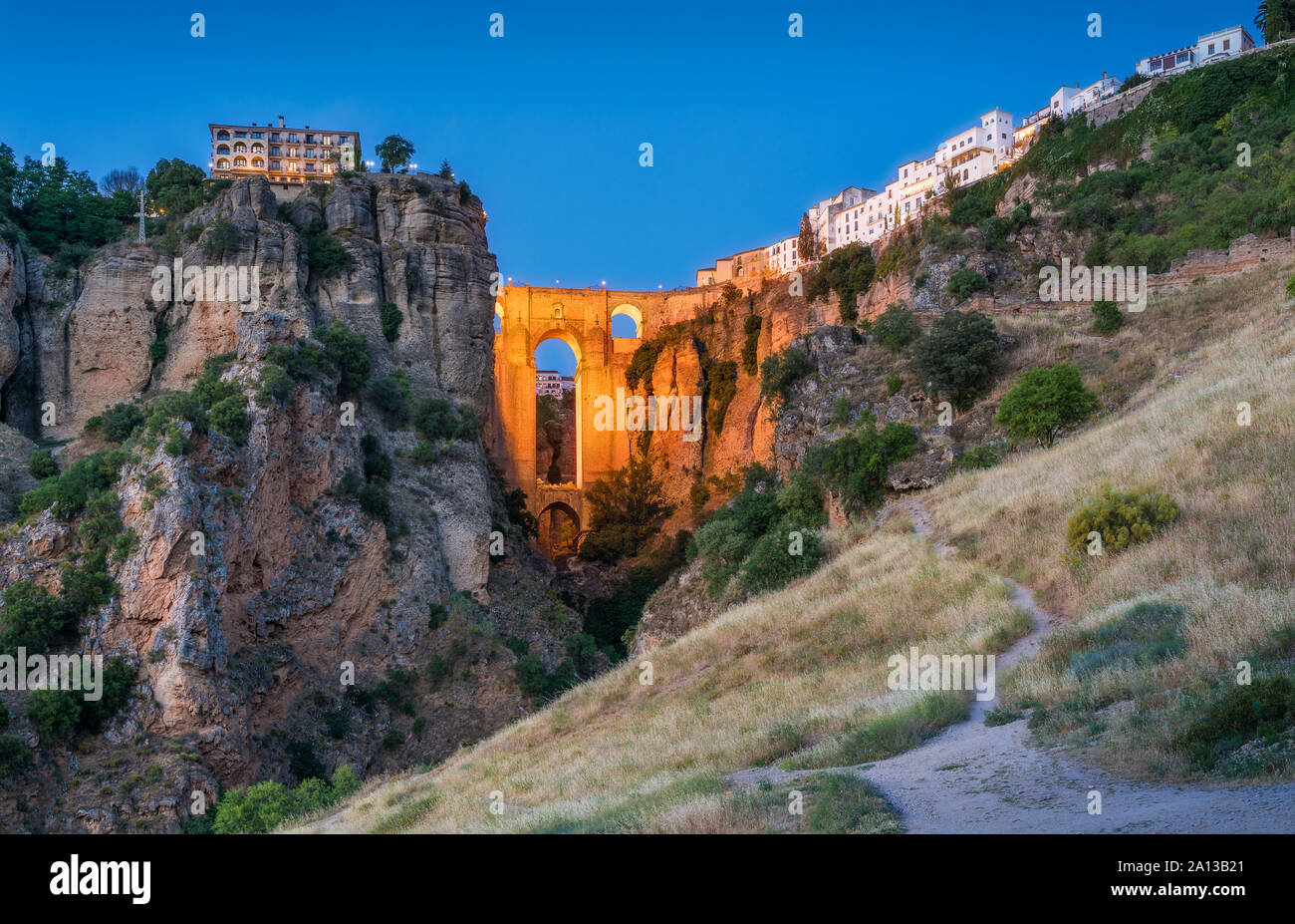 Ronda und seine historische Brücke am Abend beleuchtet. Provinz Malaga, Andalusien, Spanien. Stockfoto