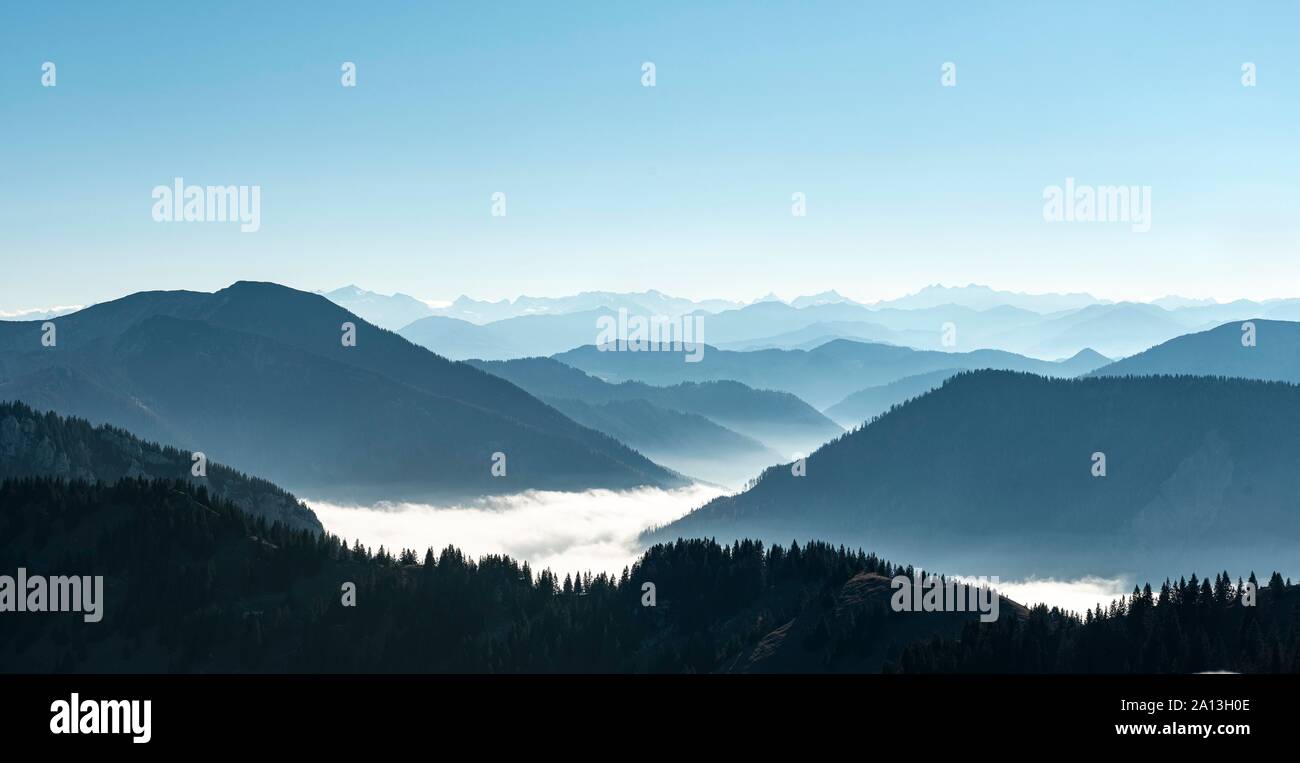 Bergketten hintereinander im Gegenlicht, Blick auf die Alpen vom Gipfel des Breitenstein, hohe Nebel über dem Tal, Fischbachau Stockfoto