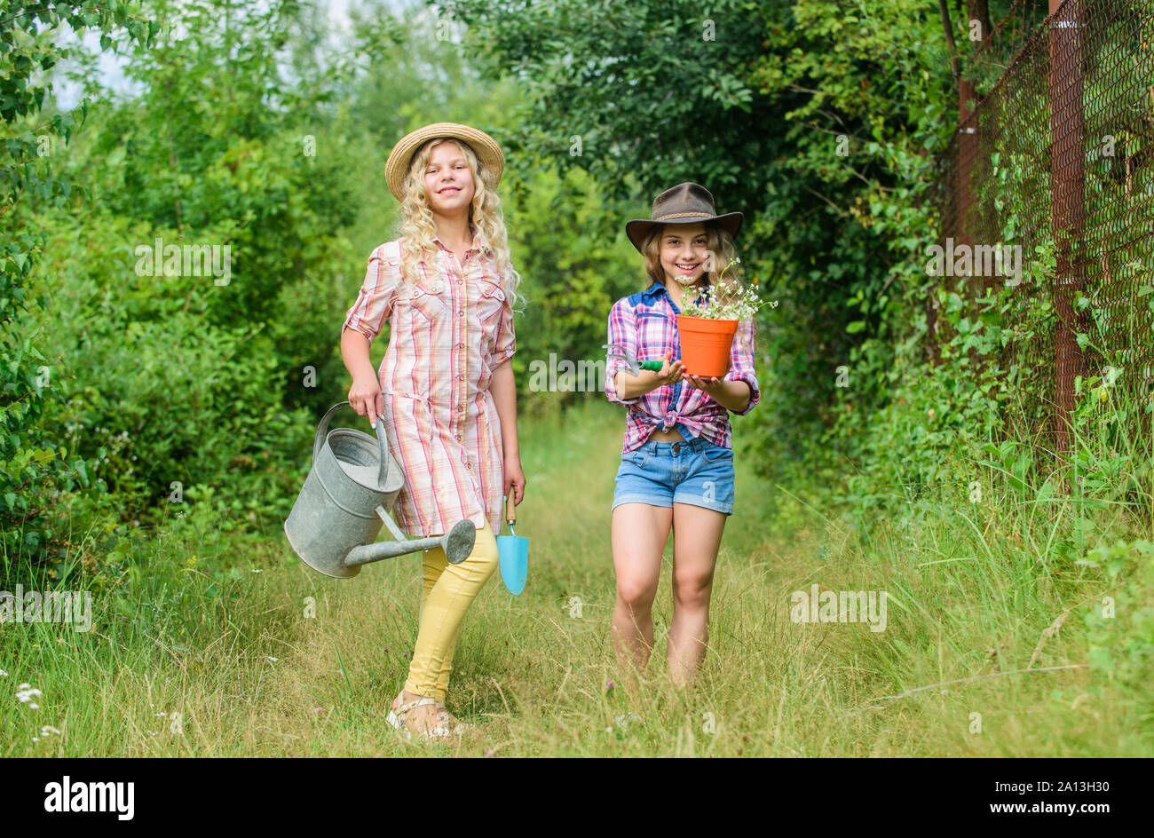 Arbeiten in grüner Umgebung. Ökologie und Umweltschutz. Kinder Gartengeräte. Tag der Erde. Sommer Familie Bauernhof. Landwirtschaft und Landwirtschaft. Feder Land. kleine Mädchen Bauer im Dorf. Stockfoto