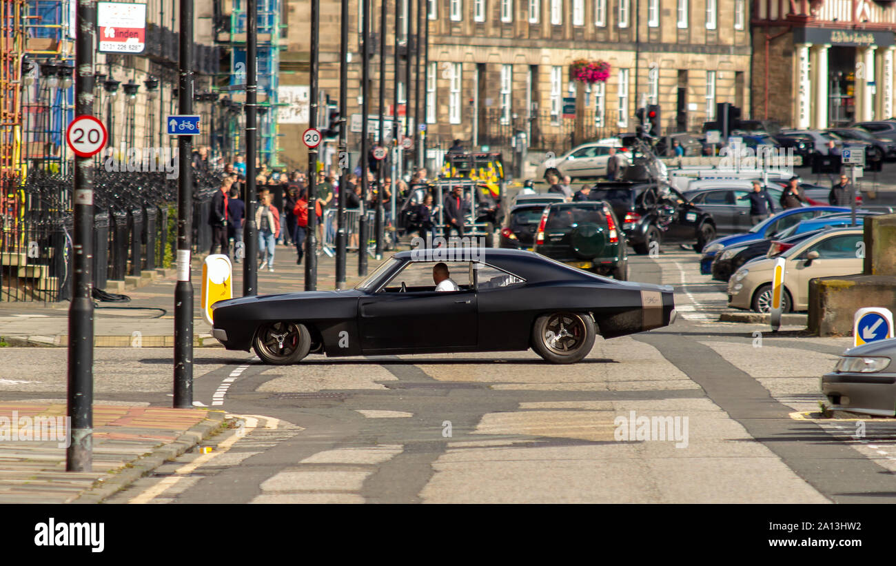 Vin Diesels stand-in fährt mit seinem Auto auf der anderen Straßenseite während der Dreharbeiten. Fast & Furious 9 hat die Produktion in Edinburgh gewickelt, nach einigen Wochen der Dreharbeiten für den neuesten Film im High-octane Verfolgungsjagd Franchise. Die letzten Szenen waren heute auf Melville Street, einem hübschen Georgian Terrace in der Hauptstadt West End erschossen. Stunt drivers, für Stars wie Vin Diesel, fuhr ihre Muscle Cars nach oben und unten die Straße, neben der Kamera. Fast & Furious 9 wird am 22. Mai 2020. Stockfoto