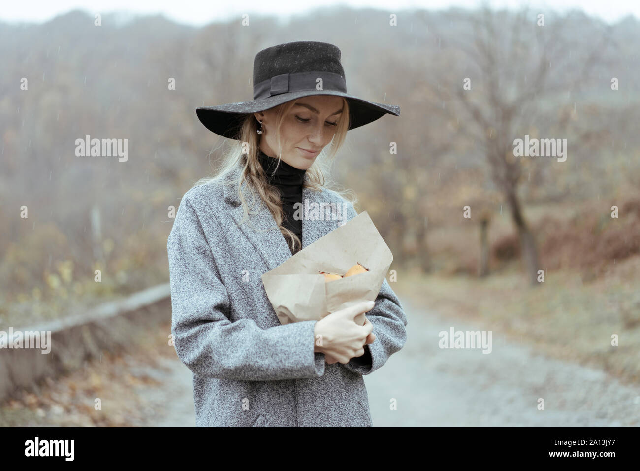 Frau in einem Hut und Mantel steht in der Regen Stockfoto