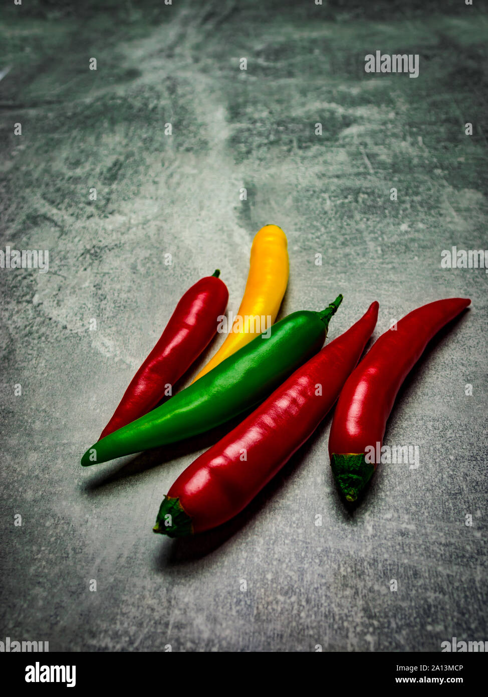 In der Nähe von fünf chili peppers in Hell-dunkel-Stil auf grauem Hintergrund. Stockfoto