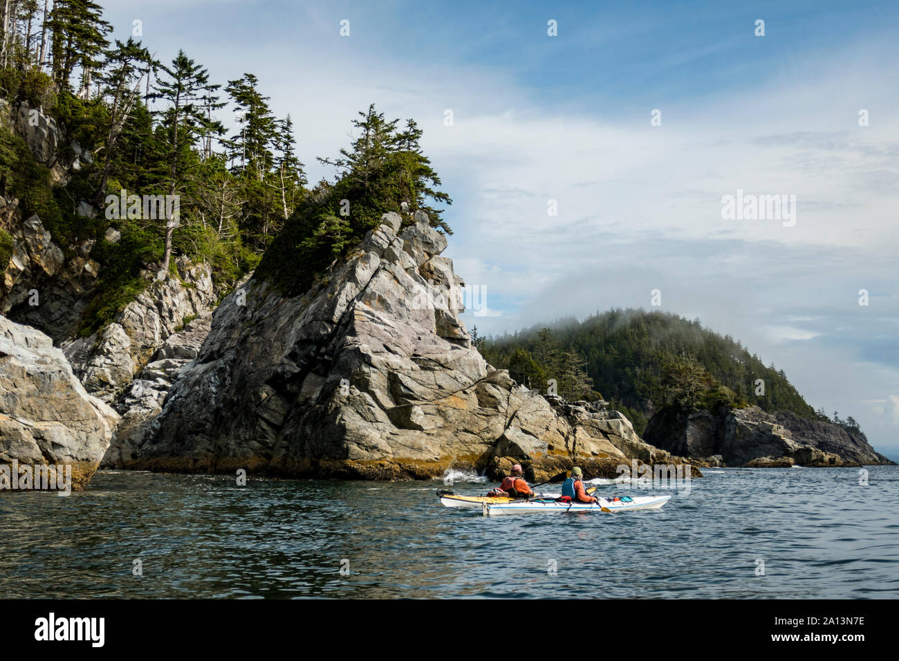 Kayaker paddeln unter den gebrochenen Gruppe Inseln im Pacific Rim National Park Reserve, British Columbia, Kanada. Stockfoto