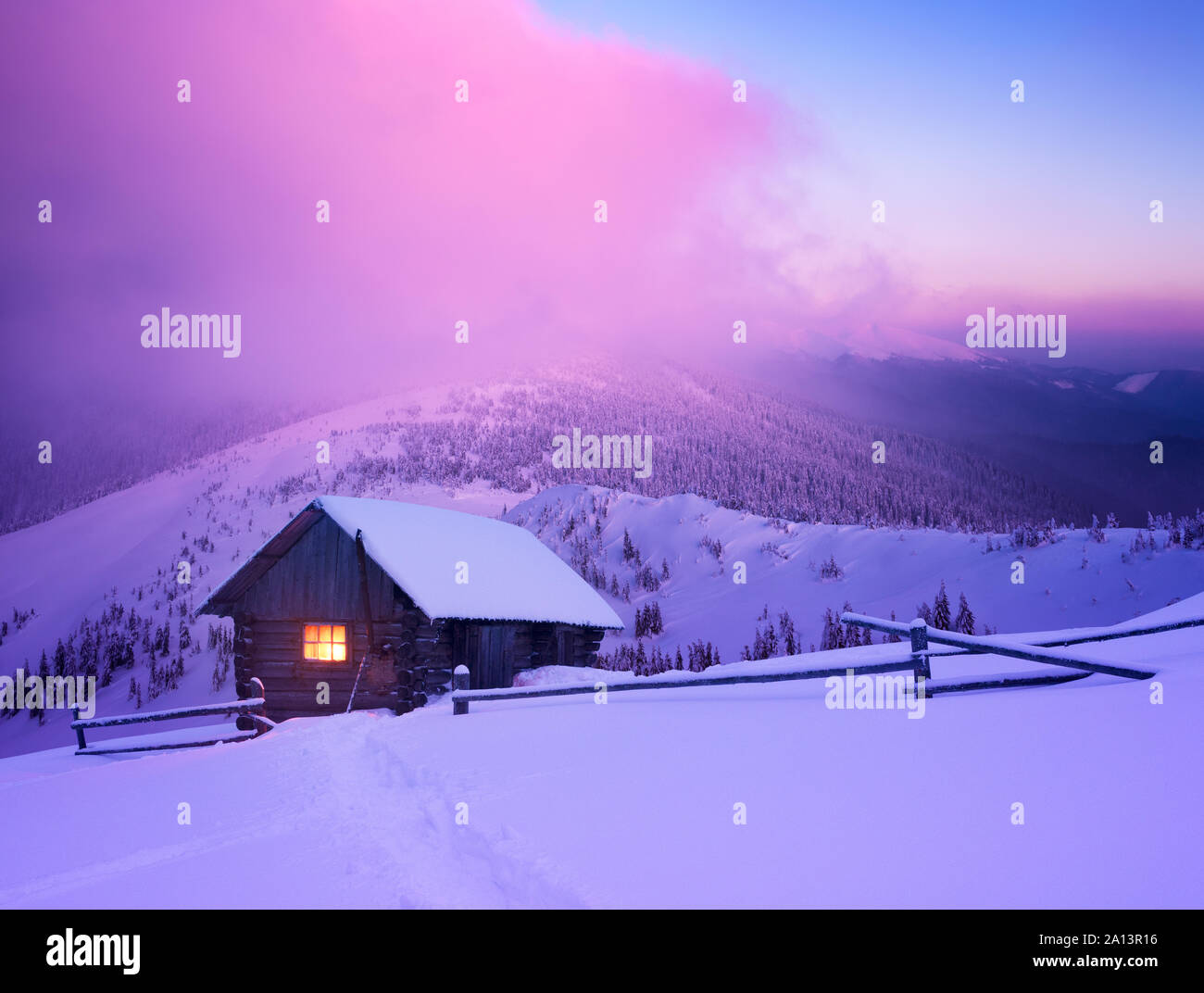 Weihnachten Landschaft mit einem Holz- Haus in den Bergen. Schönen winter Sonnenaufgang Stockfoto