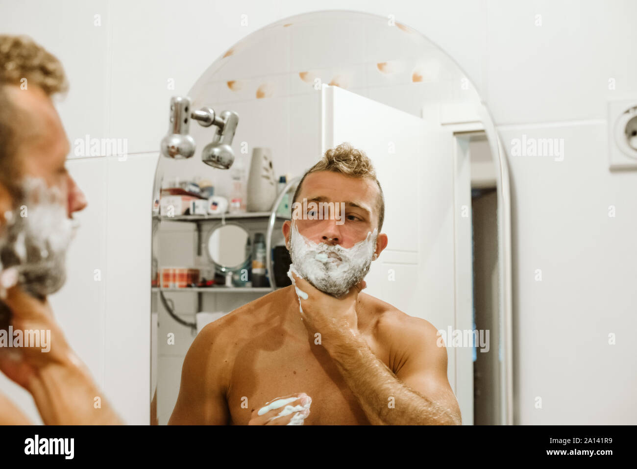 Mann rasieren Gesicht in Bad Spiegel Stockfoto