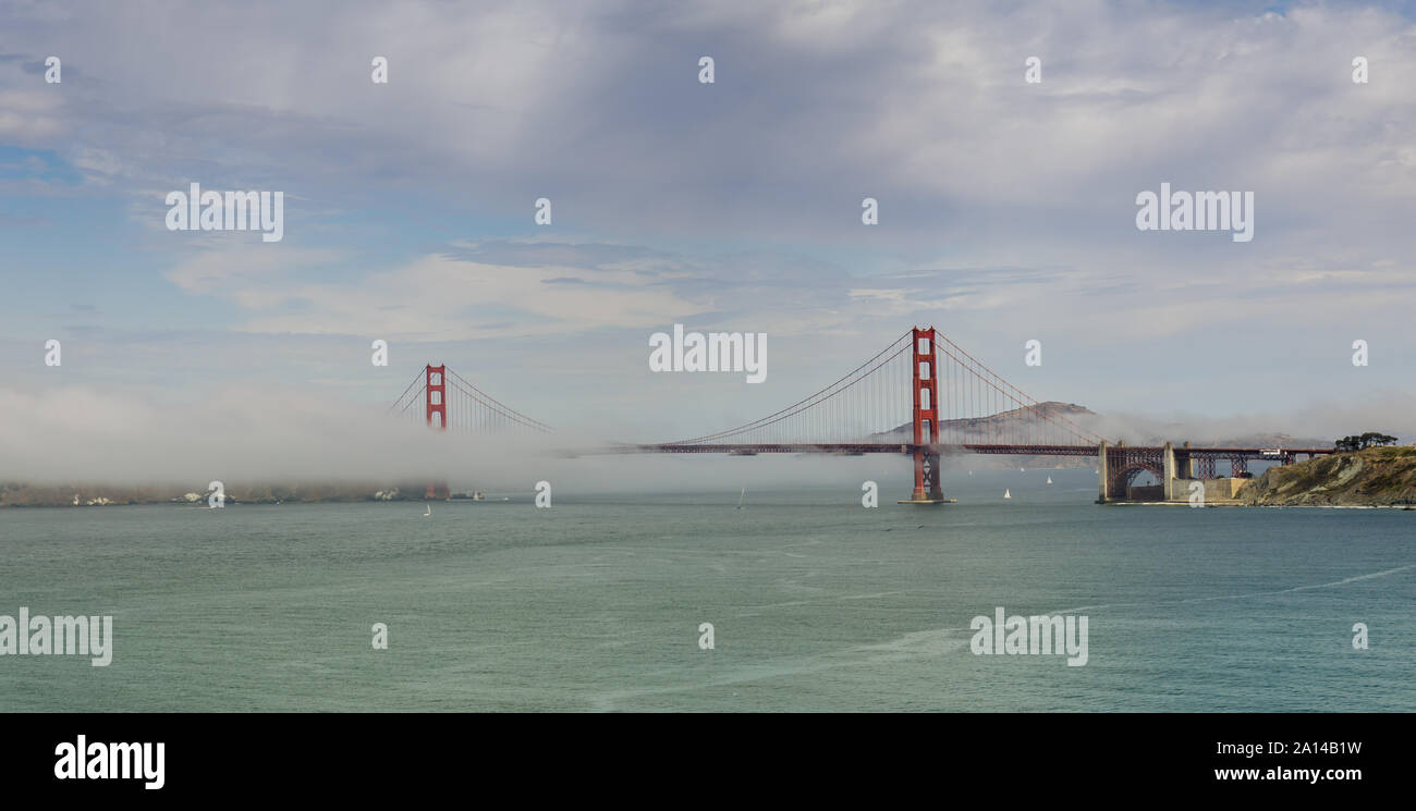 Die Golden Gate Bridge mit nebligen bewölktem Himmel wie von Land's End Trail im Richmond District gesehen Stockfoto