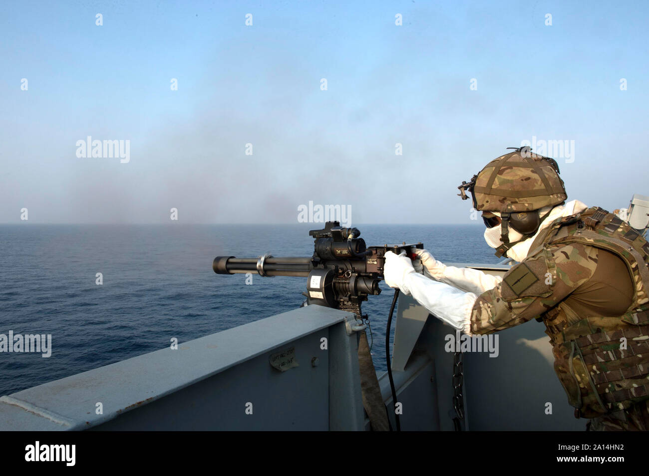 Eine königliche Marine feuert eine MK-44 Minigun an Bord des Britischen Royal Fleet Auxiliary ship Cardigan Bay. Stockfoto