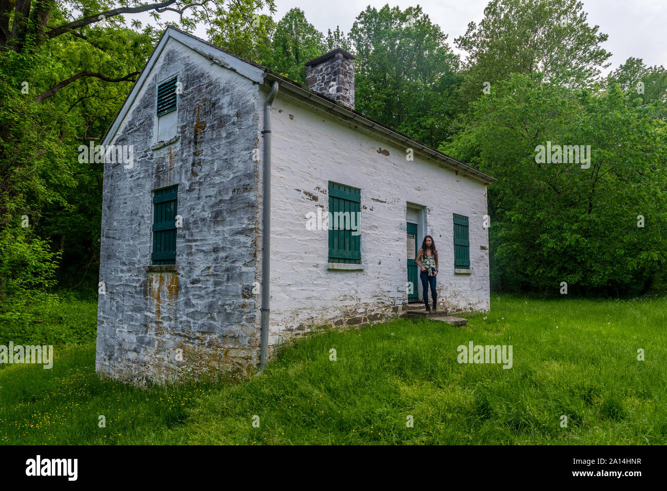 Frau von lock keepers weißes Haus mit grünen Fensterläden und Türen auf der Chesapeake und Ohio Canal Stockfoto