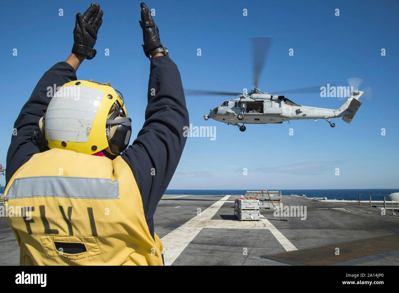 Der Luftfahrt Bootsmann Mate leitet eine MH-60S Sea Hawk Hubschrauber. Stockfoto