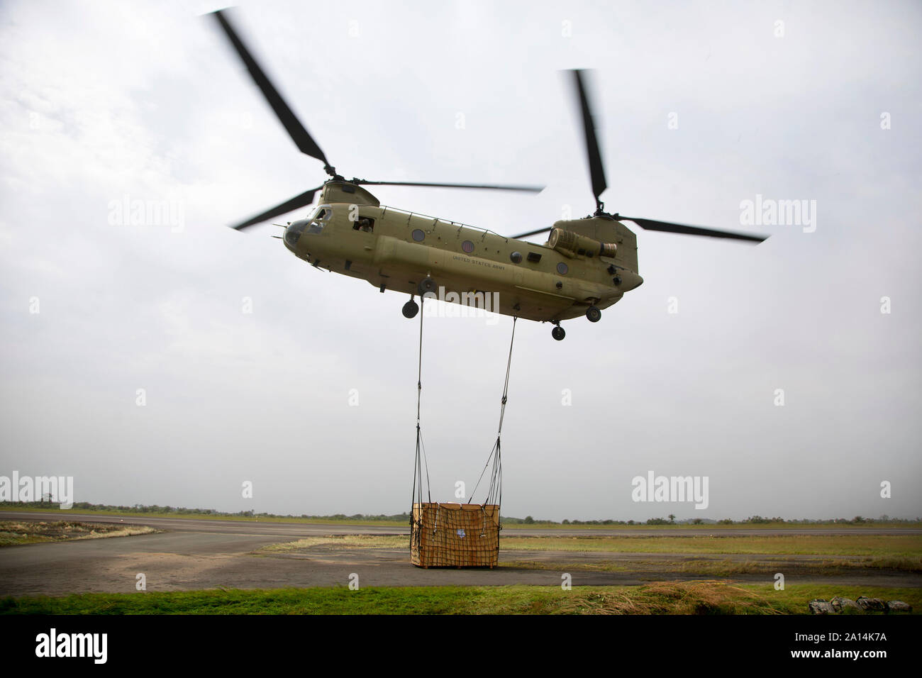 Eine CH-47 Chinook Hubschrauber beginnt eine Schlinge Last zu heben. Stockfoto
