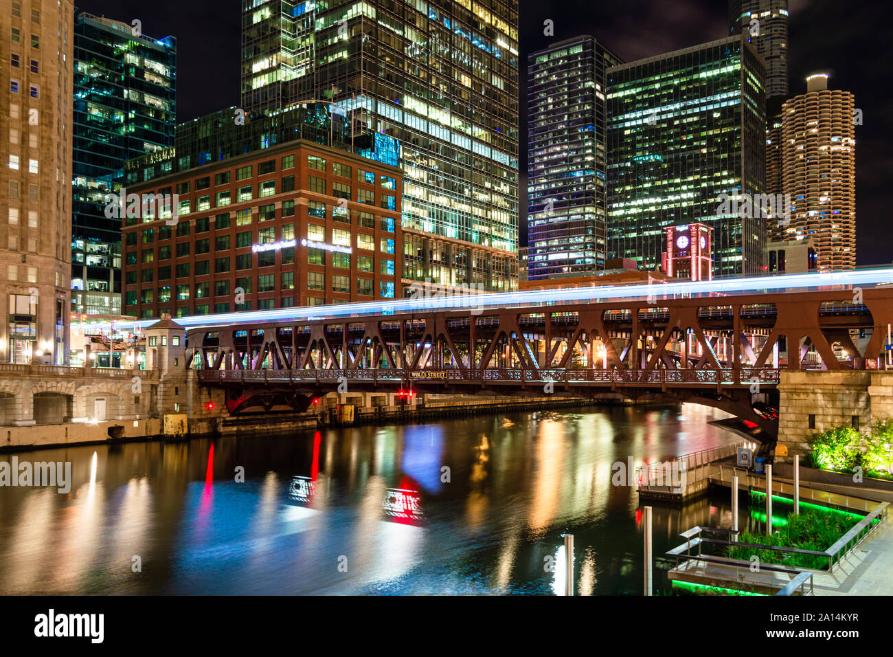 Ein Zug aus, die über den Chicago River durch die Innenstadt bei Nacht. Main Street in Chicago. Stockfoto