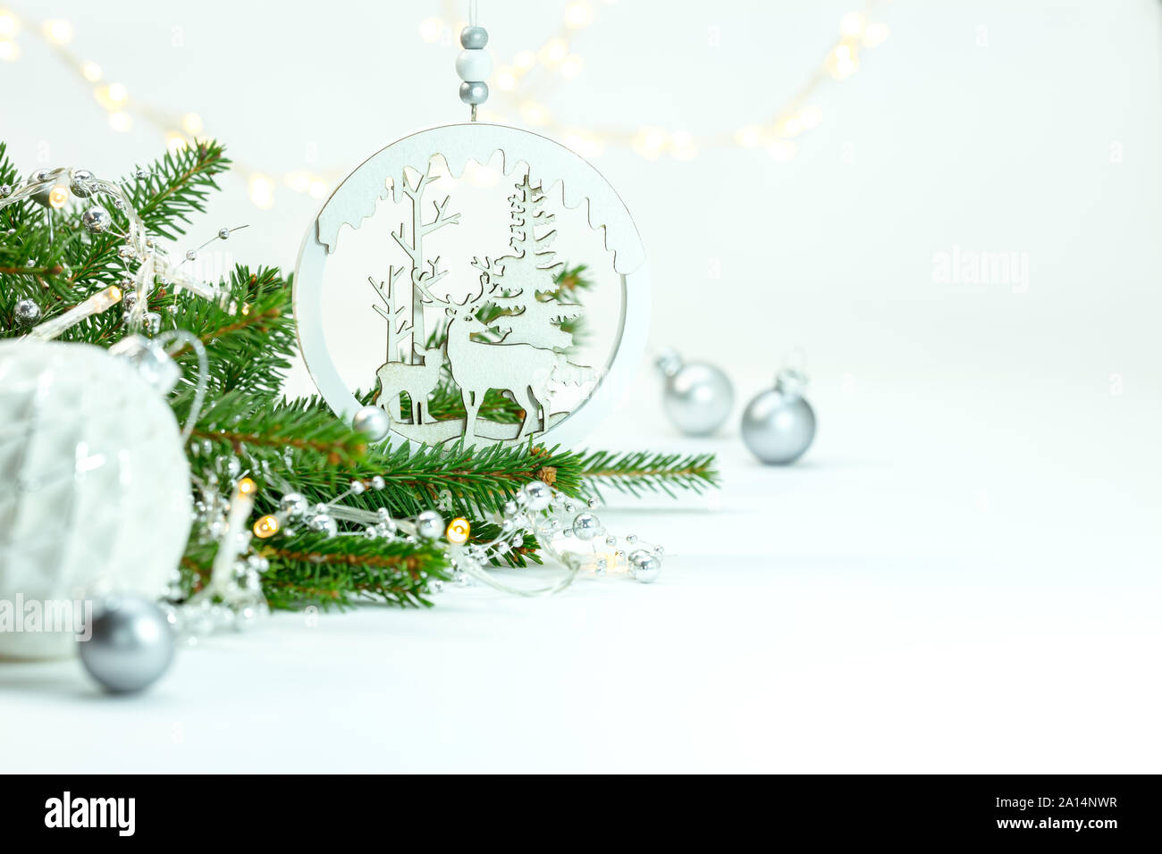 Winter Ferien und Weihnachten Dekorationen mit grünen Tannenbaum Zweig und leuchtende Girlande Lichter gegen den weißen Hintergrund Stockfoto