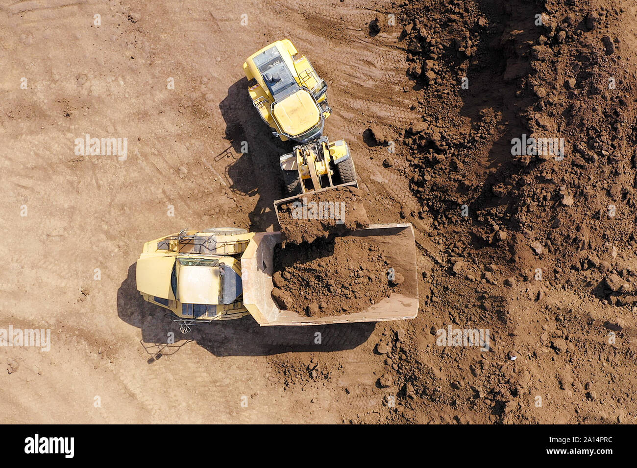 Bagger laden Boden auf einer Artikulierten hauler Truck, Top-down-Antenne Stockfoto