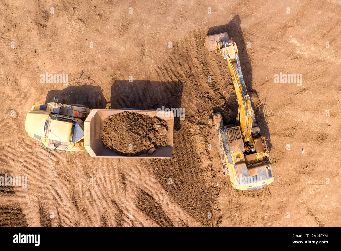 Bagger laden Boden auf einer Artikulierten hauler Truck, Top-down-Antenne Stockfoto