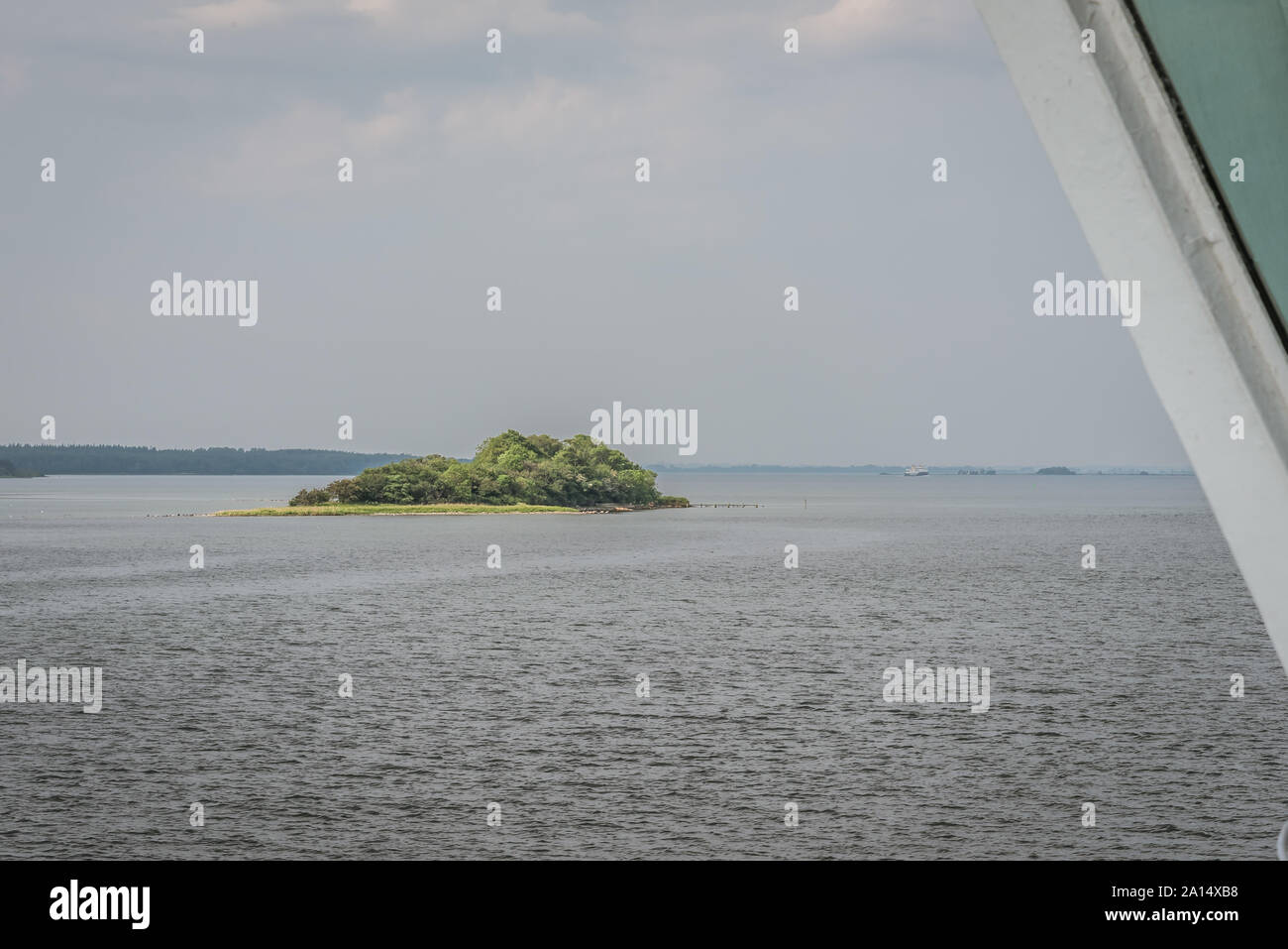 Eine kleine Insel mit grünen Bäumen allein im Ozean, von einer Fähre Fenster, Svendborg, Dänemark, 13. Juli 2019 zu sehen Stockfoto