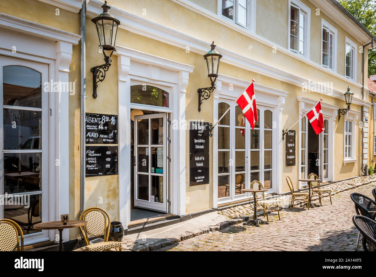 Eine alte idyllische dänische Restaurant mit Stühlen und Tischen auf dem Bürgersteig in Aeroskobing, Dänemark, 13. Juli 2019 Stockfoto