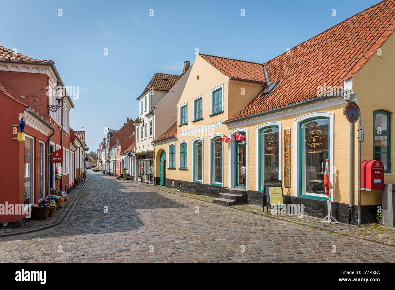 Bunte Straße mit alten Häusern und dänische Flaggen in Aeroskobing, Dänemark, 13. Juli 2019 Stockfoto