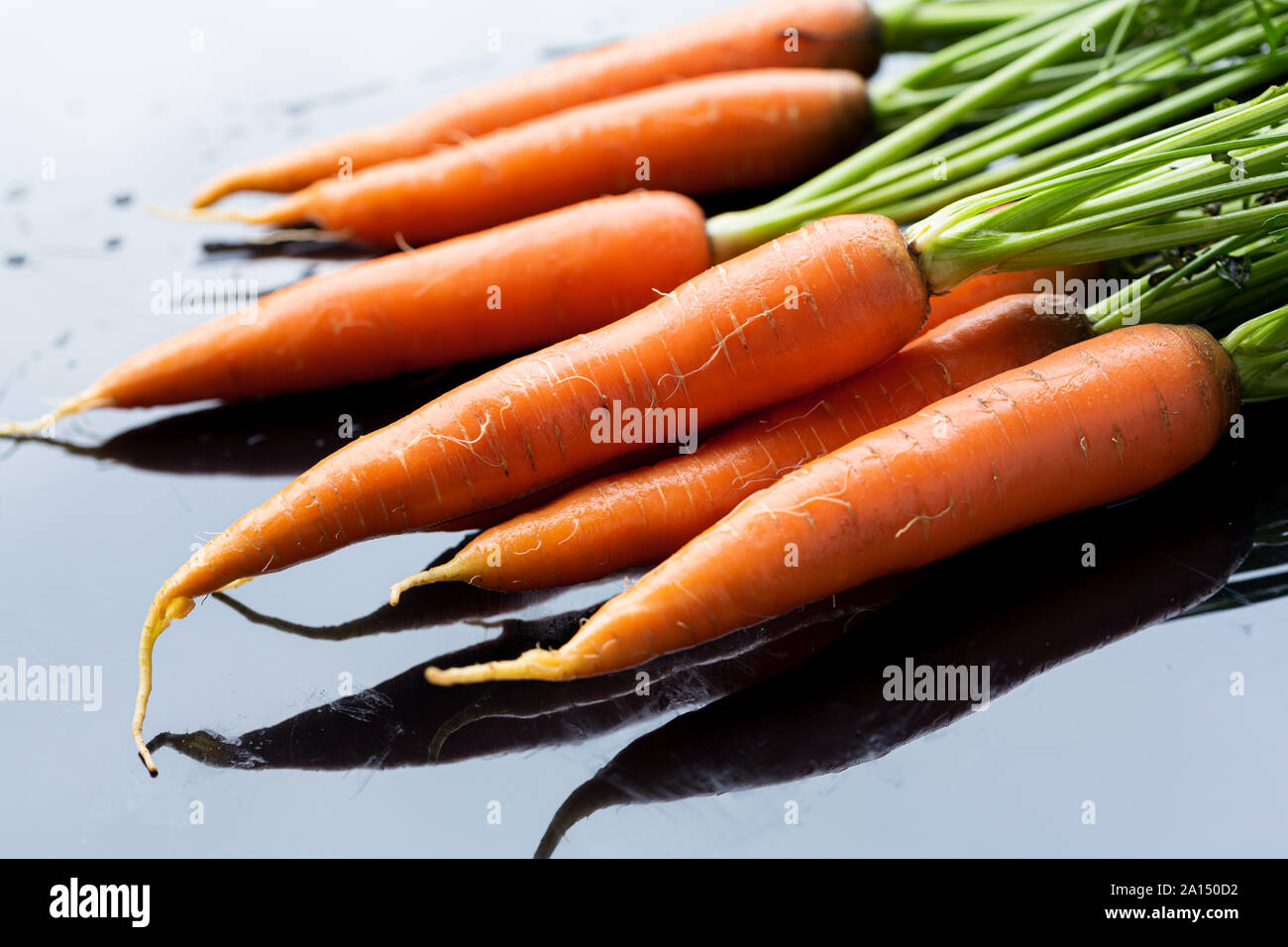 Frische Bio Karotten auf schwarze Oberfläche Stockfotografie - Alamy
