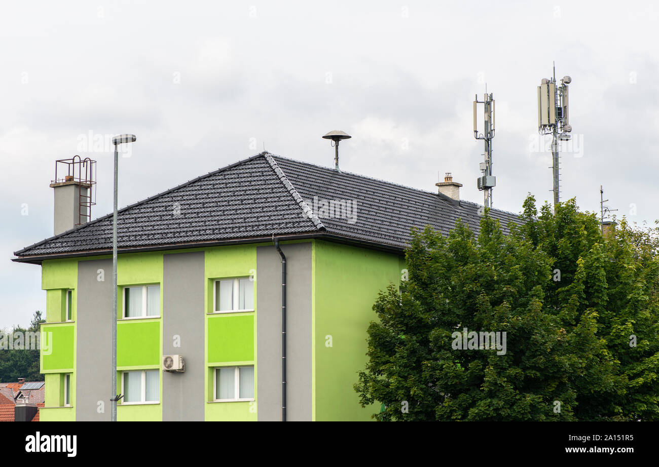 5 G Antennen an der Spitze des Hauses. Antennen und Sendeanlagen auf dem Dach. High speed mobile Internet Konzept. Stockfoto