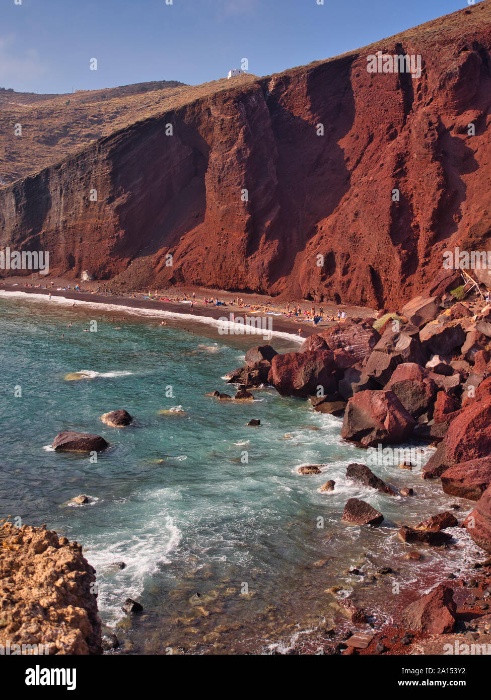 Ungewöhnlich hellen roten Bergen unter blauem Himmel und türkisfarbenem Wasser auf Kokkini Red Beach Santorini Griechenland Stockfoto