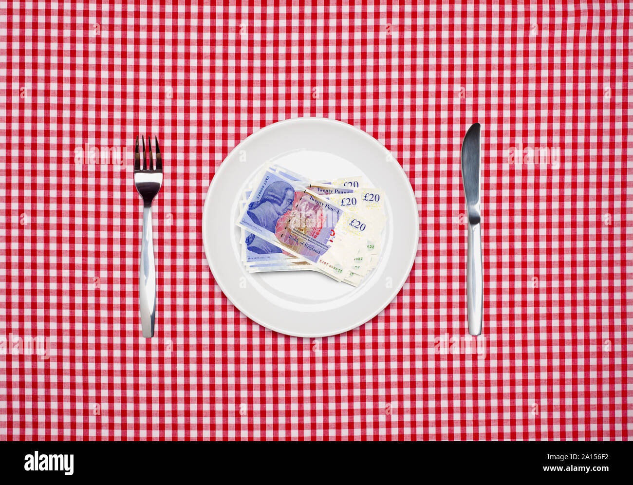 20 Pfund Noten GBP Sterling Banknoten auf einem weißen Teller mit Messer und Gabel Ansicht von oben Stockfoto