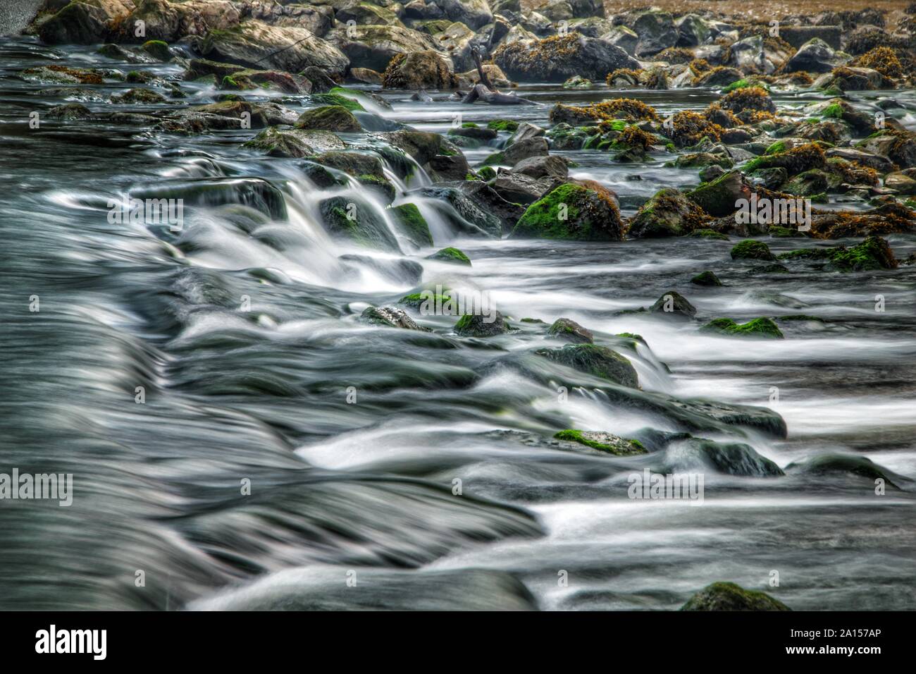 Wasser über Felsen an Lopwell Wehr, Fluss Tavy Stockfoto