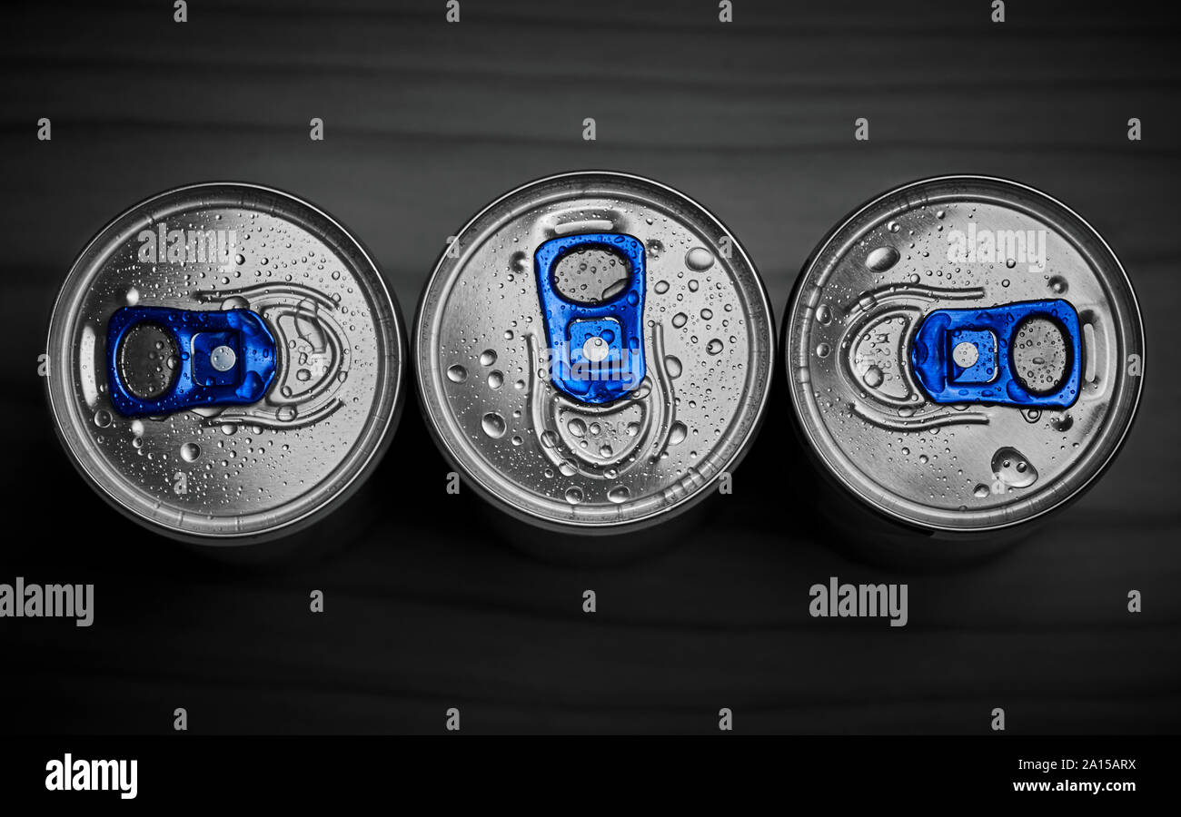 Drei Dosen energy drink mit Wassertropfen auf einem dunklen Hintergrund Stockfoto