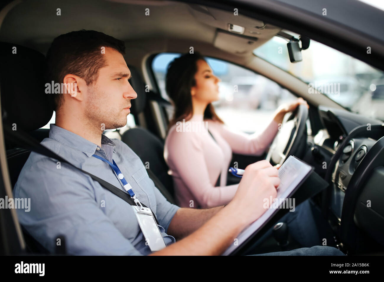 Männliche auto Kursleiter nimmt Untersuchung in der jungen Frau. Mann freuen uns und schreiben. Junge Frau Auto vorsichtig und mit Aufmerksamkeit Stockfoto