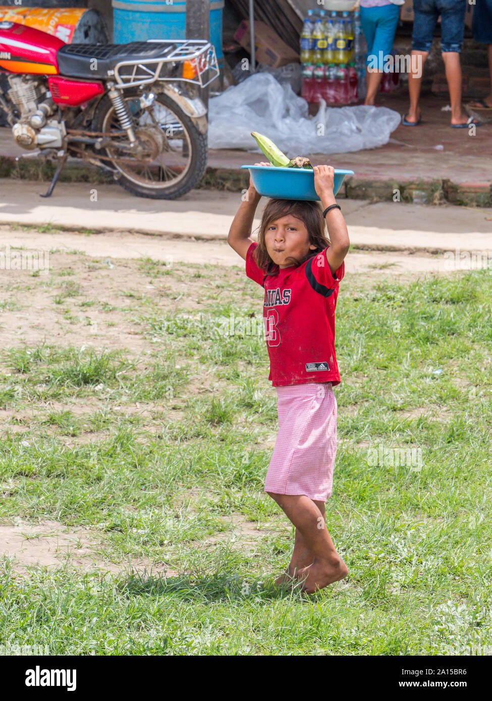 Kleines Dorf von Amazonas, Peru - Dec 03, 2018: Kinderarbeit. Kleines Mädchen Verkauf der Früchte am Ufer des Amazonas Stockfoto