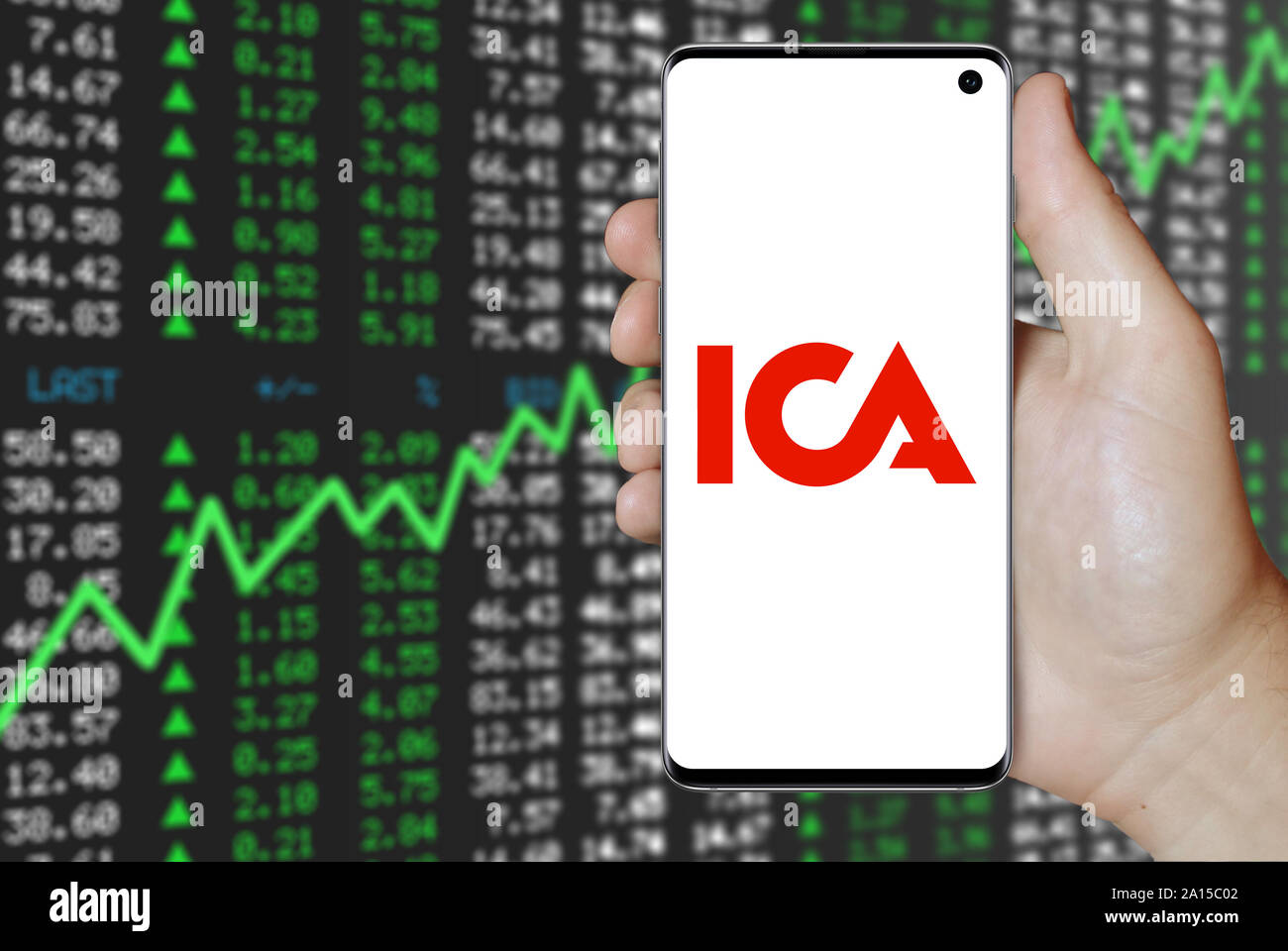 Ein Mann hält ein Smartphone mit dem Logo der Firma ICA-Gruppen im OMX Stockholm aufgeführt. Positive Börse Hintergrund. Credit: PIXDUCE Stockfoto