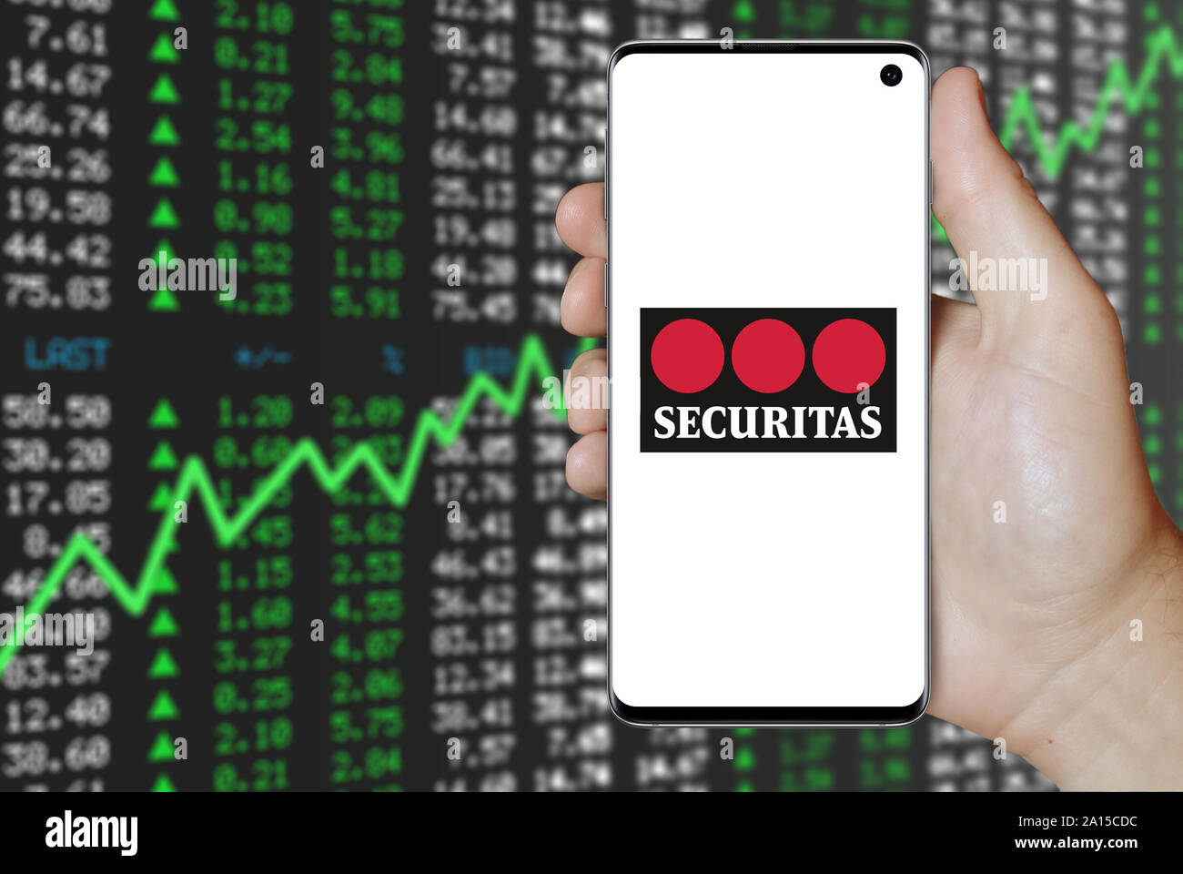 Ein Mann hält ein Smartphone mit dem Logo der Firma Securitas im OMX Stockholm aufgeführt. Positive Börse Hintergrund. Credit: PIXDUCE Stockfoto