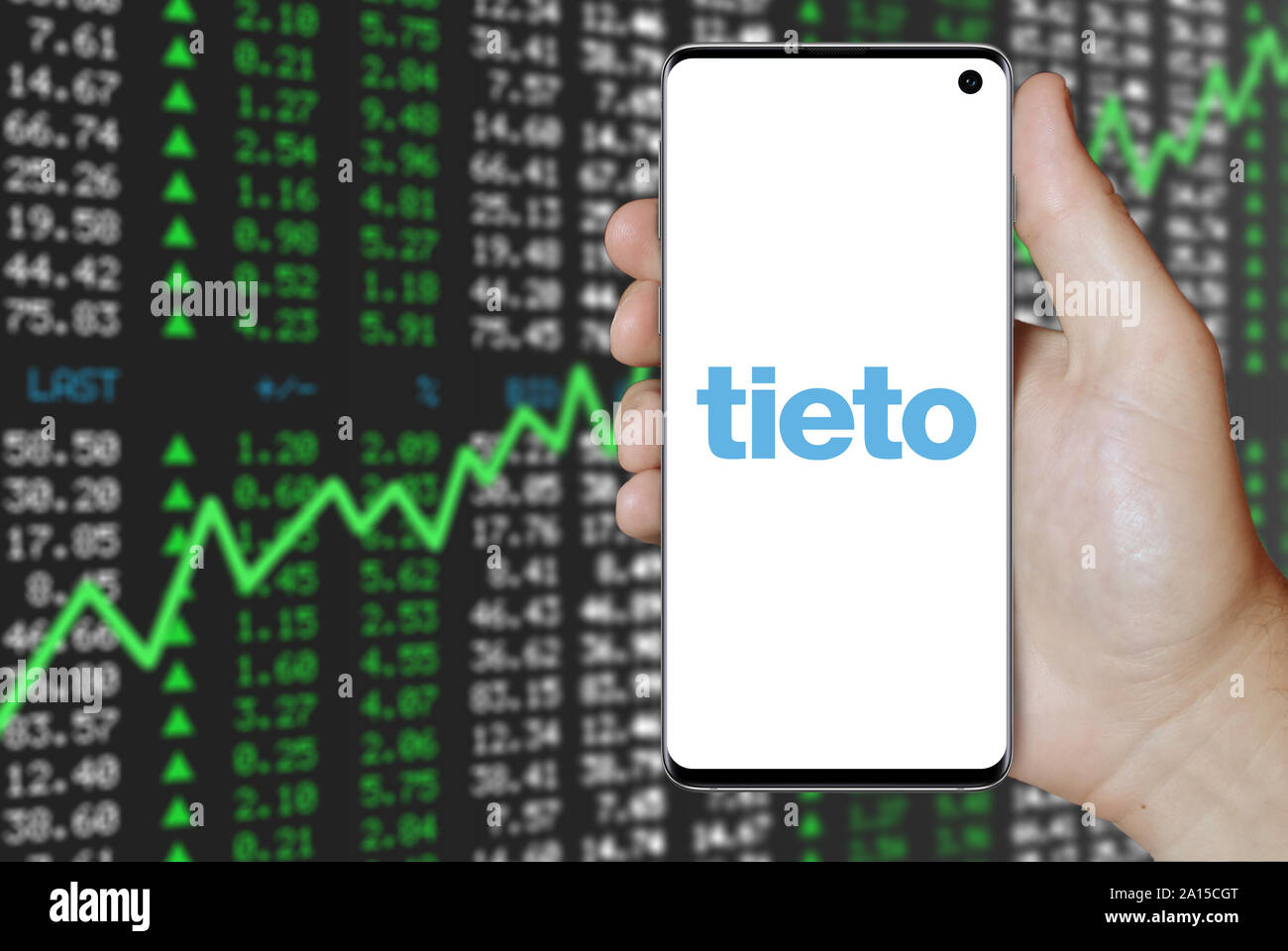 Ein Mann hält ein Smartphone mit dem Logo der Firma Tieto im OMX Stockholm aufgeführt. Positive Börse Hintergrund. Credit: PIXDUCE Stockfoto