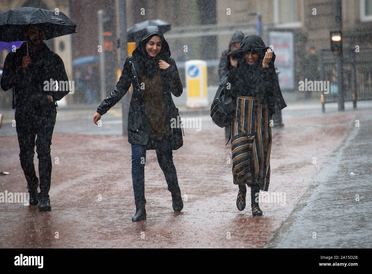 Menschen zu Fuß durch starke Niederschläge im Zentrum von Birmingham. Das Met Office hat eine gelbe Wetter Warnung für viel von England und Wales heute herausgegeben, mit Überschwemmungen in einigen Bereichen zu rechnen. Stockfoto