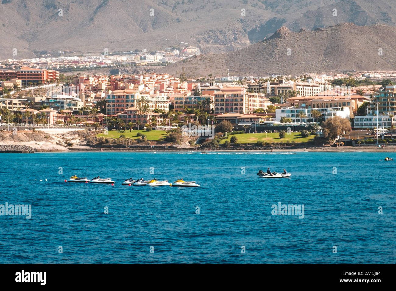 Gruppe von Jet Ski im Ozean mit Hotels am Coust im Hintergrund Stockfoto