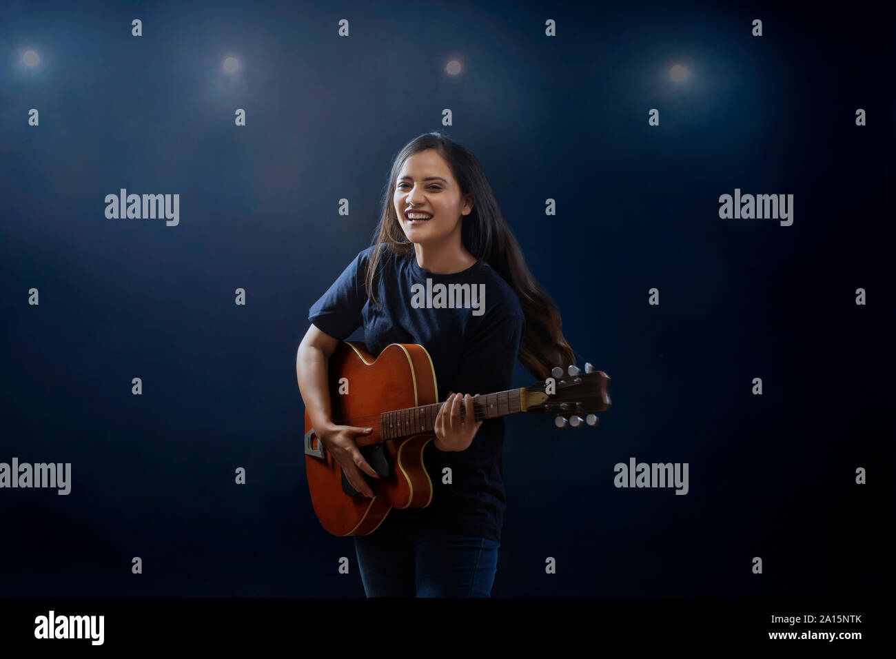 Junge Frau mit Gitarre auf der Bühne Stockfoto
