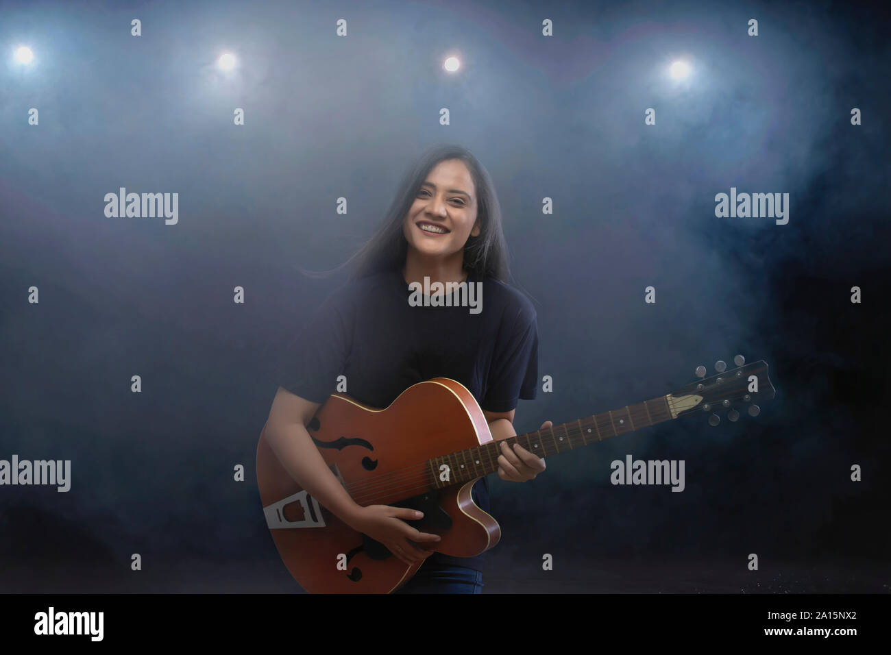 Junge Frau mit Gitarre auf der Bühne Stockfoto