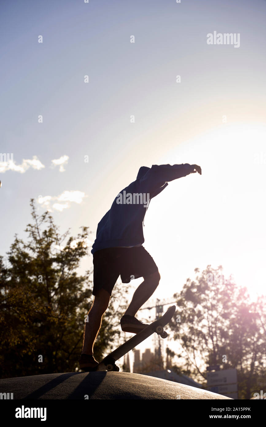 Die Silhouette eines jungen Skateboarding bei Sonnenuntergang in Barcelona, Spanien Stockfoto