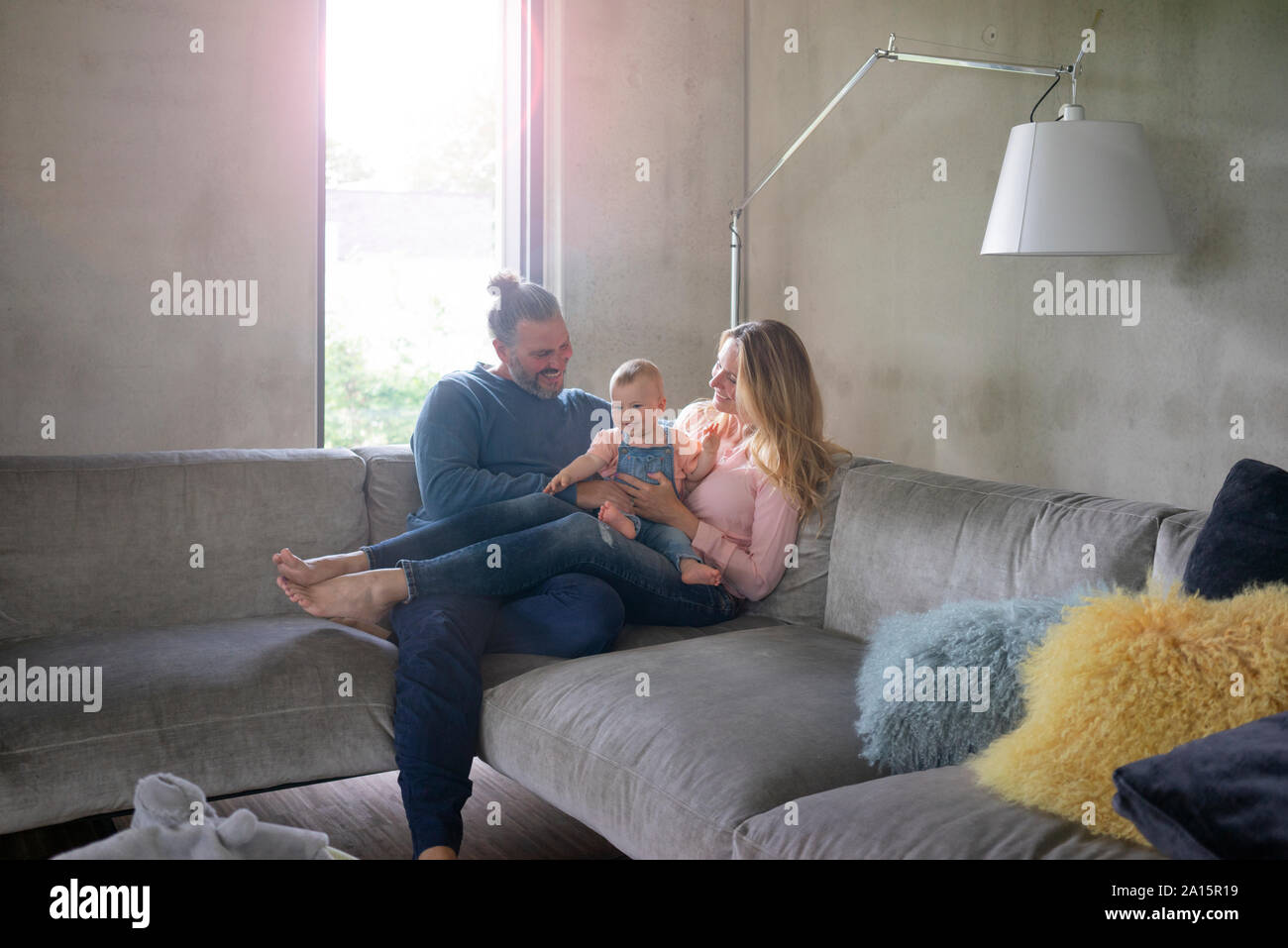 Glückliche Familie von drei Sitzen auf der Couch zu Hause Stockfoto