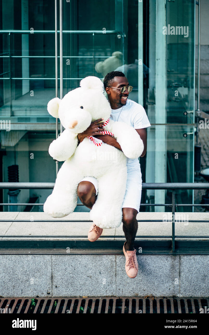 Lächelnden jungen Mann mit großer Teddybär Stockfoto