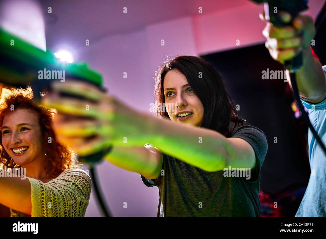 Freunde spielen und schießen mit Pistolen in eine Spielhalle Stockfoto